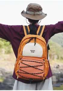 Outdoor sport backpack detail, multi-pocket design with elastic cord in orange and white.