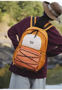 Outdoor lifestyle detail view of the vibrant yellow multi-pocket backpack worn by a model.