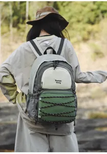 Outdoor casual backpack detail view showing color block design and elastic cord storage.