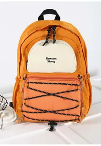 Detail shot of orange-yellow canvas backpack with contrast pocket and outdoor bungee cords.
