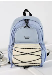 Stylish light blue canvas backpack with front bungee cord pocket detail for daily travel.