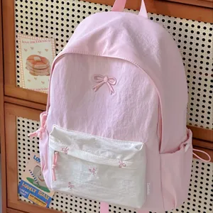 Pink backpack detail showcasing the cute bow embroidery, front white pocket, and durable material.