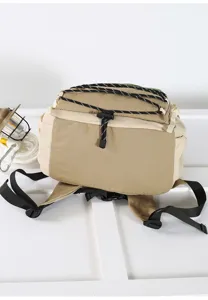 Close-up detail view of the beige and khaki casual backpack featuring durable straps and bungee cords.