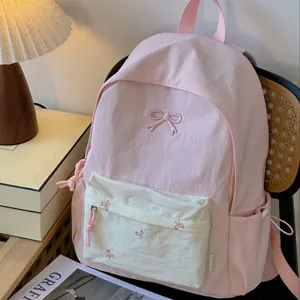 Pink Japanese style canvas school backpack with cute bow embroidery for teen girls casual use.