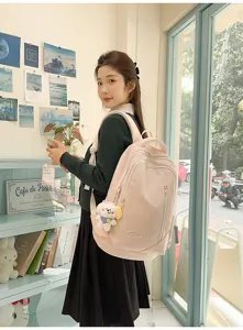 Large capacity pink school backpack for women with cute puppy pendant and multiple zipper pockets.