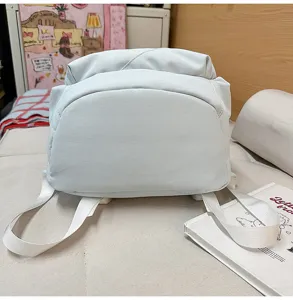Detail view of casual light blue backpack strap and surface texture in daily lifestyle scene.