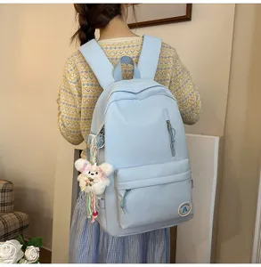 Cute sweet campus style women's light blue casual backpack with plush bear pendant and front pocket.