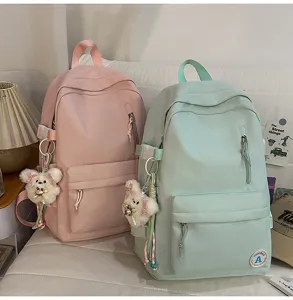 Detail view of Korean style candy color student backpack with cute bear keychain.