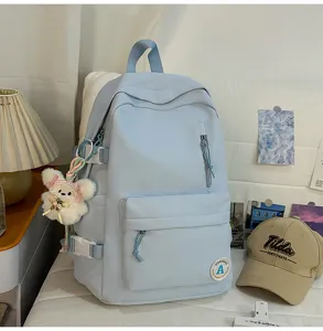 Detailed view of the light blue college style backpack with front zipper pocket and cute plush.