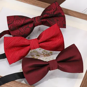 Detailed close-up of classic red and burgundy bow ties featuring paisley and solid textures.