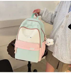 Vista dettagliata dello zaino scolastico multicolore con tasca anteriore e ciondolo in peluche.