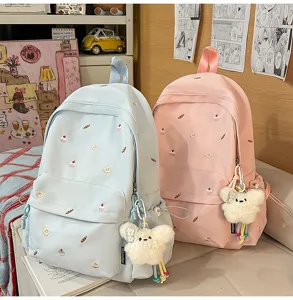 Charming student backpack detail featuring sweet dessert embroidery, fluffy bear pendant.