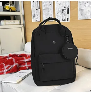Detailaufnahme des schwarzen Rucksacks mit Fronttasche, Henkel und kleiner runder Tasche.