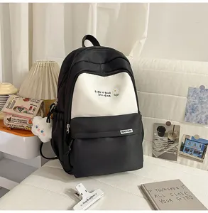 Vista dettagliata dello zaino scolastico nero e bianco elegante con tasche e ricamo.