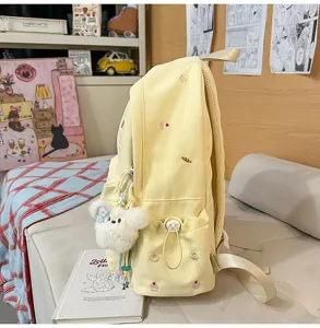 Cute yellow aesthetic school backpack with cute embroidery and fluffy bear pendant.