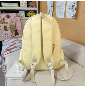 Casual yellow school backpack detail view, featuring comfortable straps and zipper pocket.