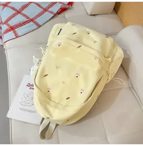 Cute embroidered school backpack with cake patterns, casual campus style in light yellow.