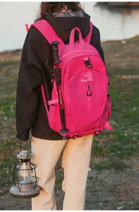 Outdoor pink backpack detail view with trekking poles and camp lantern in nature setting