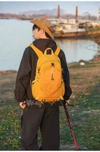 Outdoor backpack detail showing waterproof yellow fabric, zipper pockets and straps.