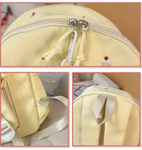 Close-up detail view of the yellow canvas backpack zipper, shoulder strap and top handle.