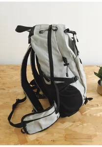 Detailed side view of the grey outdoor mountaineering backpack showcasing strap and mesh pocket.