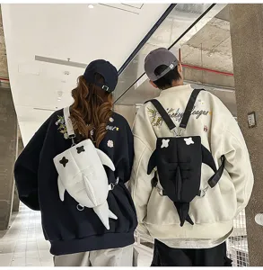 Detail view of trendy shark shape shoulder backpacks worn by couple, cute and stylish design.