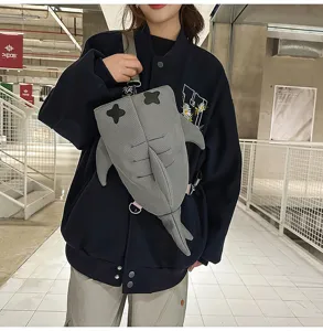 Detailed view of the cute grey shark sling bag, featuring fun fin design and adjustable strap.