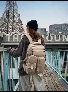 Outdoor lifestyle scene showing details of a large capacity khaki multi-pocket travel backpack.