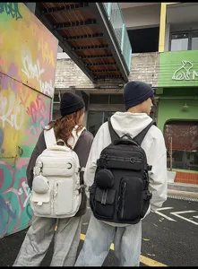 Urban street style scene displaying multi-pocket casual backpacks outdoors with models.