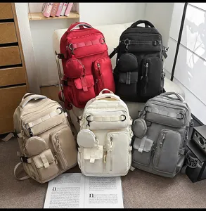 Detail view of multi-pocket canvas backpacks in various colors for travel and school use.