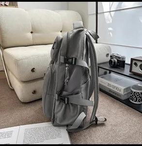 Large capacity grey casual backpack, side view showing multiple pockets and adjustable straps.
