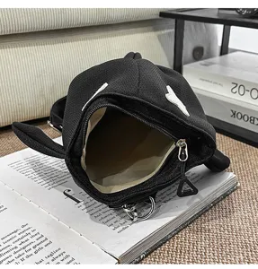Detail view of the black shark shaped shoulder bag interior opening with zipper and unique fins.