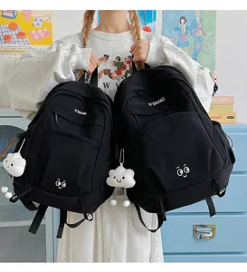 Detailed view of casual black school backpack with cute cloud pendant and front letter print.
