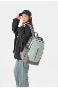 Detailed view of stylish grey and green dual-tone backpack worn by model, large capacity.