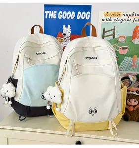 Color-block canvas student backpack with cute cloud charm, spacious travel casual daypack detail.