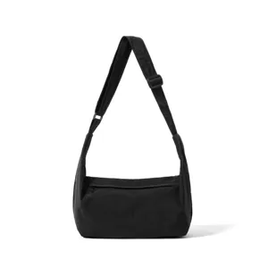 Detail view of the black minimalist nylon crossbody bag featuring a convenient front zipper.