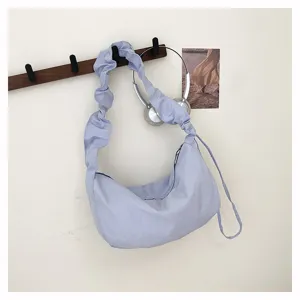 Detailed view of light purple pleated hobo shoulder bag hanging on wall hook, nylon casual style.