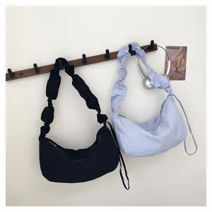 Detail shot of casual pleated nylon crossbody bag with shoulder strap, stylish dumpling bag daily use