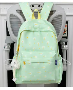 Detailed view of the cute light green backpack with dandelion print and fluffy white charm pendant.