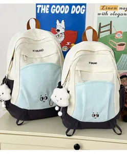 Detail shot showing cute color-block school backpacks with cloud pendants and front pockets.