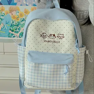 Detail view of cute Japanese style student backpack with polka dot and gingham pattern design.