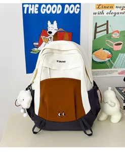 Color-block student backpack detail showing cute embroidery and multi-pocket storage.