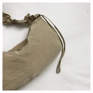 Close-up detail of casual ruched nylon shoulder bag, soft slouchy fabric and drawstring.