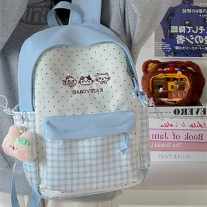Light blue polka dot backpack detail showing cute cat embroidery and plaid front pocket style.