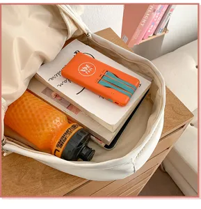 White backpack interior detail showing spacious capacity with books and daily essentials.