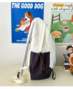 Close-up detail of color-blocked backpack with adjustable drawstring pocket and mesh straps.