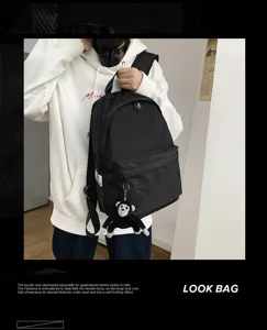 Casual black backpack for school and travel with cute monkey pendant, spacious design.
