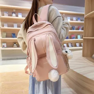 Pink cute bunny ears backpack for women girls, stylish school bag with fluffy tail decor.