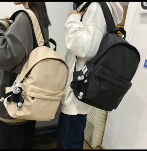 Detailed shot of minimalist nylon school backpack with cute monkey pendant for daily use.