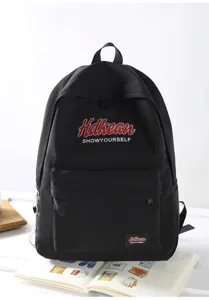 Detail view of the black college style backpack, showcasing front pocket and brand lettering.